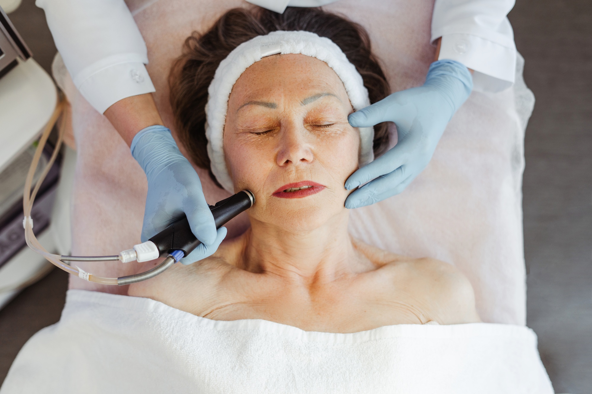 Close-up of mature woman getting facial hydro peeling treatment at cosmetic beauty spa clinic